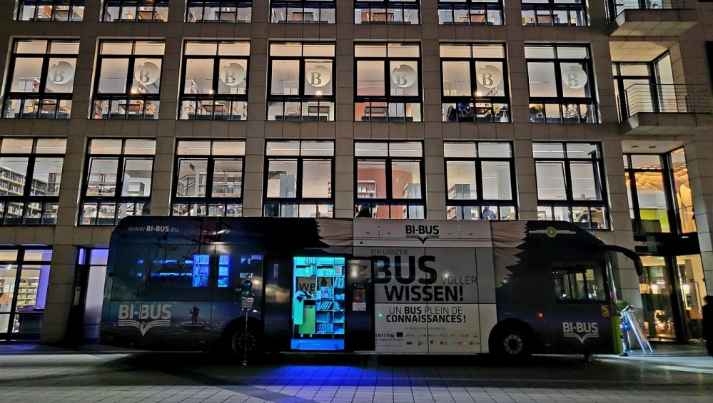 BI-BUS der Stadtbibliothek Saarbrücken im Halbdunkel vor der Fensterfront der Stadtbibliothek BI-BUS der Stadtbibliothek Saarbrücken im Halbdunkel vor der Fensterfront der Stadtbibliothek