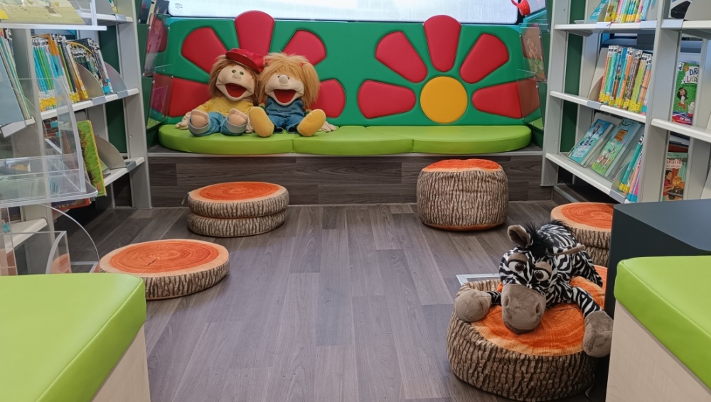Sitzbereich mit Bank, Puppen und Sitzkissen im BI-BUS der Stadtbibliothek Saarbrücken Sitzbereich mit Bank, Puppen und Sitzkissen im BI-BUS der Stadtbibliothek Saarbrücken